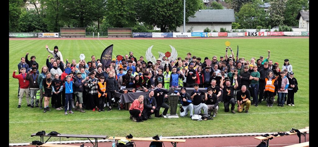 Gruppenfoto aller Teilnehmenden auf dem Sportplatz