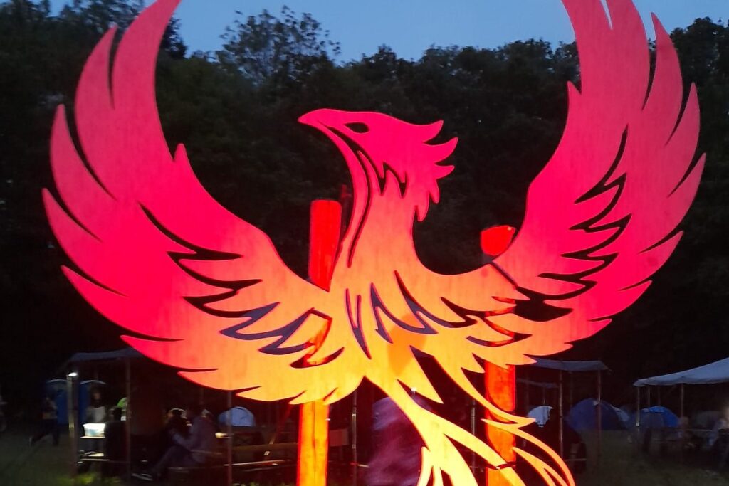 Leuchtender Phoenix mit ausgebreiteten Flügeln bei Dämmerung auf dem Veranstaltungsgelände